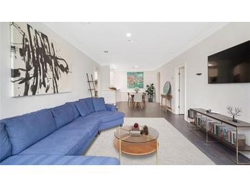 Bright living room featuring a comfortable blue sectional, art, and an open dining area, perfect for modern living at 2499 Peachtree Ne Rd # 503, Atlanta, GA 30305