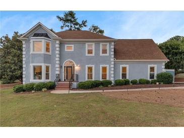 Charming two-story home boasts a well-manicured lawn and inviting curb appeal in a lovely neighborhood at 771 James Cir, Lawrenceville, GA 30046