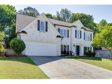 Charming two-story home with painted brick, black shutters, well-manicured lawn, and attached two-car garage at 1755 Waters Ferry Dr, Lawrenceville, GA 30043