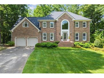 Stately two-story brick home featuring manicured lawn, symmetrical design, and attached two-car garage at 2841 Landing Dr, Marietta, GA 30066