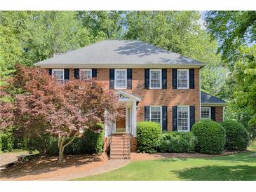 Charming brick home with black shutters, mature trees, and well-manicured landscaping at 3625 Stonehenge Ne Way, Marietta, GA 30066