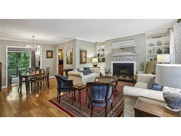 Bright living room featuring fireplace, hardwood floors, and elegant furnishings at 407 River Mill Cir # 407, Roswell, GA 30075