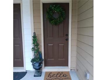 Charming front door with a seasonal wreath, a welcome mat, and a decorative plant at 101 Dewey Rd, Lilburn, GA 30047