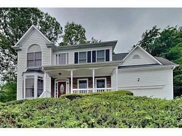 Charming two-story home with a covered front porch and well-maintained landscaping at 2001 Fairbrook Ln, Woodstock, GA 30189