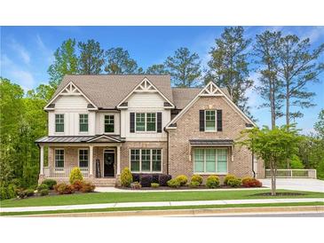 Charming two-story home featuring a brick facade, well-manicured lawn, and inviting front porch at 2622 Running River Ct, Lawrenceville, GA 30045