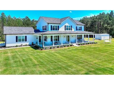 Beautiful two-story home with a large manicured lawn and a charming covered front porch at 1621 Dixie Rd, Covington, GA 30014