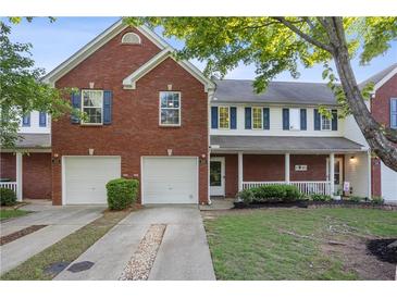 Charming townhome featuring brick facade, complemented by blue shutters and a well-manicured lawn at 210 Cottonwood Creek Cir, Canton, GA 30114