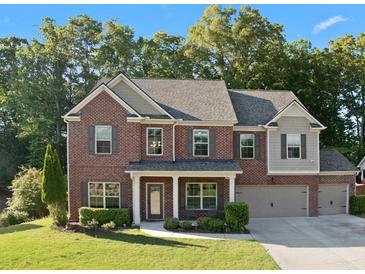 Beautiful two-story brick home with a well-manicured lawn and attached two car garage at 211 Parc Dr, Canton, GA 30114