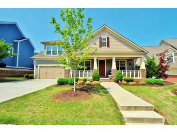 Charming home with a well-manicured lawn, lovely landscaping, and a welcoming front porch at 1005 Woodbury Rd, Canton, GA 30114