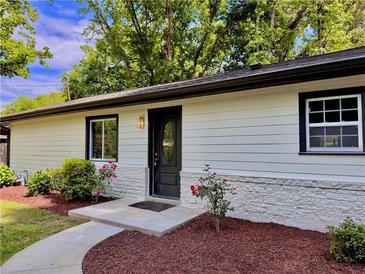Charming single-story home features a well-manicured lawn with stone accents and a black front door at 1819 Waldrep Se Cir, Marietta, GA 30060