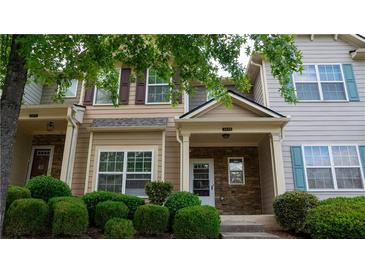 Inviting townhome showcasing charming exteriors and well-manicured landscaping, complete with a stone-accented entryway at 2476 Suwanee Pointe Dr, Lawrenceville, GA 30043