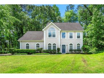 Charming two-story home with a well-manicured lawn and lush green trees in a quiet suburban neighborhood at 2312 Mahogany Glen Pl, Lawrenceville, GA 30043