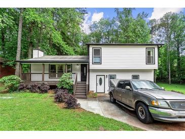 Charming two-story home with a covered front porch, manicured lawn, and a driveway with parking at 5006 Dekalb Way, Stone Mountain, GA 30087