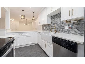 Modern kitchen featuring white cabinetry, granite countertops, and stainless steel appliances and farm sink at 502 Brighton Pt, Atlanta, GA 30328