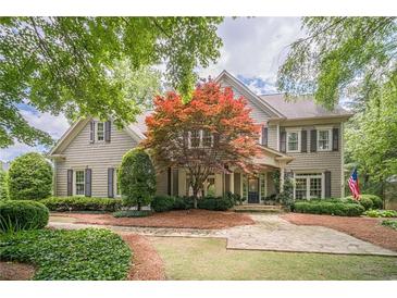 Charming two-story home featuring a well-manicured lawn, symmetrical design, and gray color palette at 5650 Buckleigh Pointe, Suwanee, GA 30024