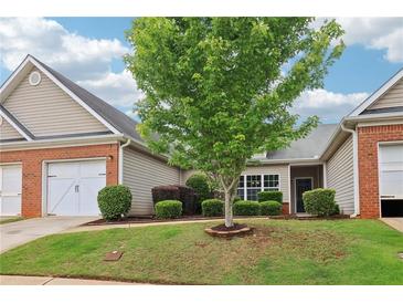 Charming townhome exterior features a well-manicured lawn, brick accents, and an attached garage at 1065 City Park Dr, Mcdonough, GA 30252
