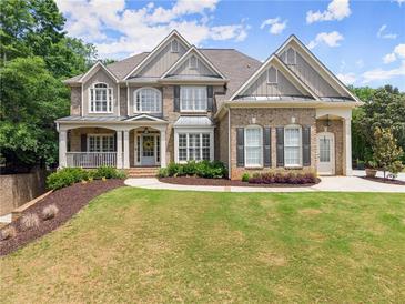 Charming two-story brick home with a manicured lawn, inviting porch, and meticulously maintained landscaping at 4525 E Point Dr, Cumming, GA 30041