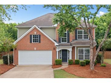 Charming brick two-story home with a manicured lawn, two car garage and mature trees at 508 Canton Ct, Canton, GA 30115