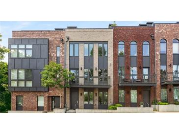 Modern townhomes featuring brick exteriors, black trim, balconies and professionally landscaped front yards at 1225 Chelsea Nw Cir, Atlanta, GA 30318