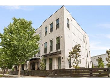 Beautiful three-story brick home with black trim, manicured landscaping, and a secure privacy fence at 1815 La Dawn Nw Ln, Atlanta, GA 30318
