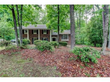 Charming brick two-story home with black shutters surrounded by lush greenery and mature trees at 3539 Evans Mill Rd, Lithonia, GA 30038