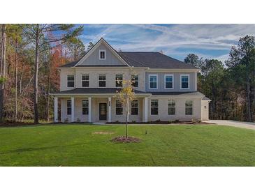 Beautiful two-story brick home with a covered porch and lush green lawn at 76 Homesite Dulles Dr, Mcdonough, GA 30253