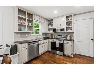 Well-lit kitchen with stainless steel appliances, hardwood floors, and bright window at 1320 Country Acres Ln, Lawrenceville, GA 30045