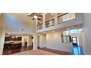 Bright living room with hardwood floors, high ceilings, open concept, and an adjacent kitchen at 5010 Lynnonhall Ct, Stonecrest, GA 30038
