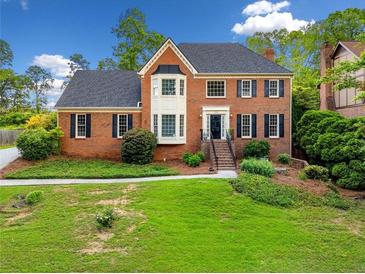 Charming brick two-story home with manicured lawn and mature trees, offering classic curb appeal at 720 Belgrave Ln, Tucker, GA 30084