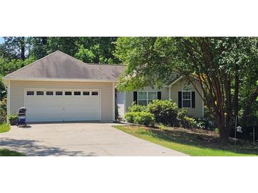 Charming home featuring an attached two car garage, traditional curb appeal, and a well-manicured lawn at 239 Clear Brook Trl, Douglasville, GA 30134