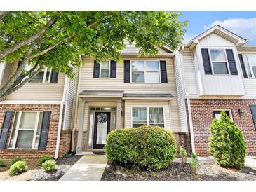 Charming townhome showcasing brick accents, neutral siding, black shutters, and a well-manicured front yard at 7244 Rockhouse Rd, Austell, GA 30168
