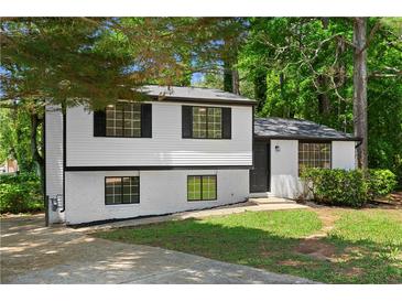 Charming renovated home with a modern color scheme and inviting curb appeal surrounded by mature trees at 1275 Muirforest Way, Stone Mountain, GA 30088