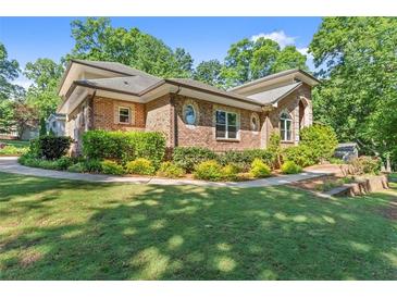 Lovely brick home featuring pristine landscaping and a well-maintained lawn at 5816 Chamblee Dunwoody Rd, Atlanta, GA 30338