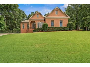 Beautiful brick home with manicured lawn and mature trees in a desirable neighborhood at 7940 Gable Dr, Douglasville, GA 30135