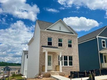 Charming two-story home featuring brick facade and covered front porch under a blue and cloudy sky at 2733 Creek View Nw Ter, Atlanta, GA 30318