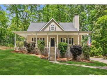 Charming home with a welcoming front porch, lush lawn, and well-maintained landscaping at 3845 Pilgrim Mill Rd, Cumming, GA 30041