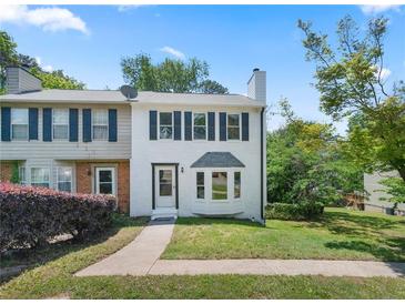 Charming two-story townhouse with a well-manicured lawn and freshly painted white exterior at 1505 Cedar Bluff Trl, Marietta, GA 30062