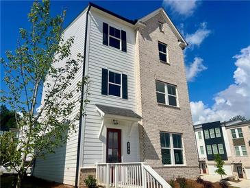 Beautiful three-story home boasts mixed materials, a red door and a manicured lawn at 2731 Stream Valley Lane Nw Nw Cir, Atlanta, GA 30318