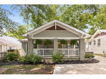 Charming bungalow with a welcoming front porch and well-maintained landscaping with black mulch at 2486 Memorial Se Dr, Atlanta, GA 30317