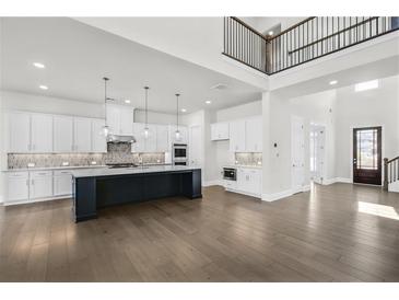 Stunning kitchen boasts a large island, stainless steel appliances, and ample white cabinetry at 6660 Wallace Farms Dr, Cumming, GA 30028