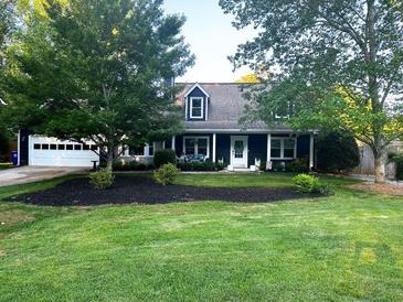 Charming home featuring a well-manicured front yard, attached garage, and inviting front porch at 209 Hearthstone Reach, Peachtree City, GA 30269