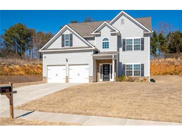 Charming two-story home features a well-manicured lawn, a two-car garage, and a welcoming entrance at 33 N Village Cir, Rydal, GA 30171