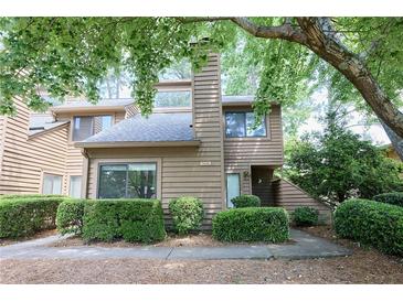 Inviting townhouse featuring a neutral color, a chimney, and lush landscaping at 1606 Parkaire Xing # 1606, Marietta, GA 30068