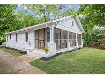 Charming white home featuring a screened-in porch, perfect for relaxing outdoors at 1591 Jonesboro Se Rd, Atlanta, GA 30315
