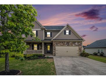 Charming two-story home with a stone facade, two-car garage, and well-manicured lawn at twilight at 13 Cottage Nw Walk, Cartersville, GA 30121