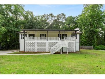 Charming home with a white lattice-covered porch and a well-maintained front yard surrounded by lush trees at 4170 Maroney Mill Rd, Douglasville, GA 30134