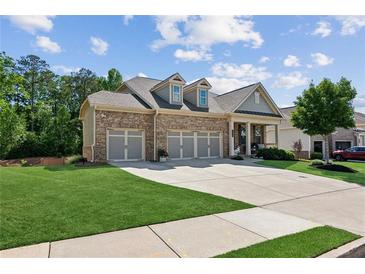 Charming brick home featuring a three-car garage, well-manicured lawn and inviting curb appeal at 2470 Crimson Downs Dr, Cumming, GA 30040