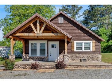 Charming one-story home with wood siding, covered porch, brick foundation, and beautifully landscaped yard at 3049 Highway 411 Ne, White, GA 30184