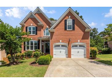 Charming two-story brick home with a well-manicured lawn and a two-car garage at 210 Wentworth Ter, Alpharetta, GA 30022