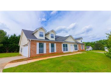 Charming two-story home with brick accents, dormer windows, and well-manicured lawn at 213 Whistle Way, Locust Grove, GA 30248